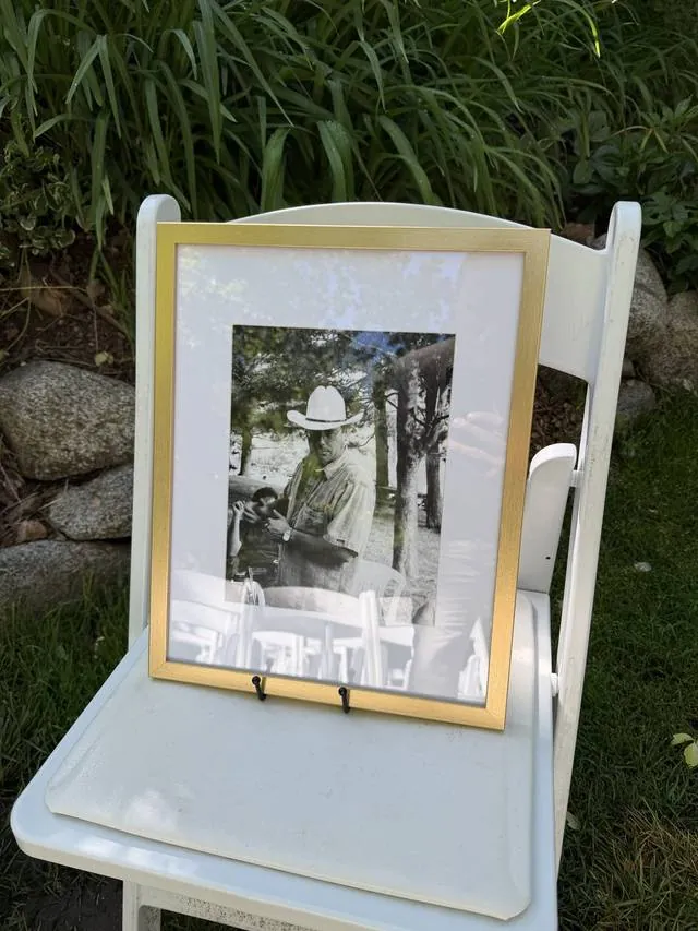 A framed black and white photograph of a cowboy on a garden chair