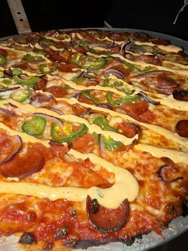 A whole pepperoni and jalapeno pizza, close up