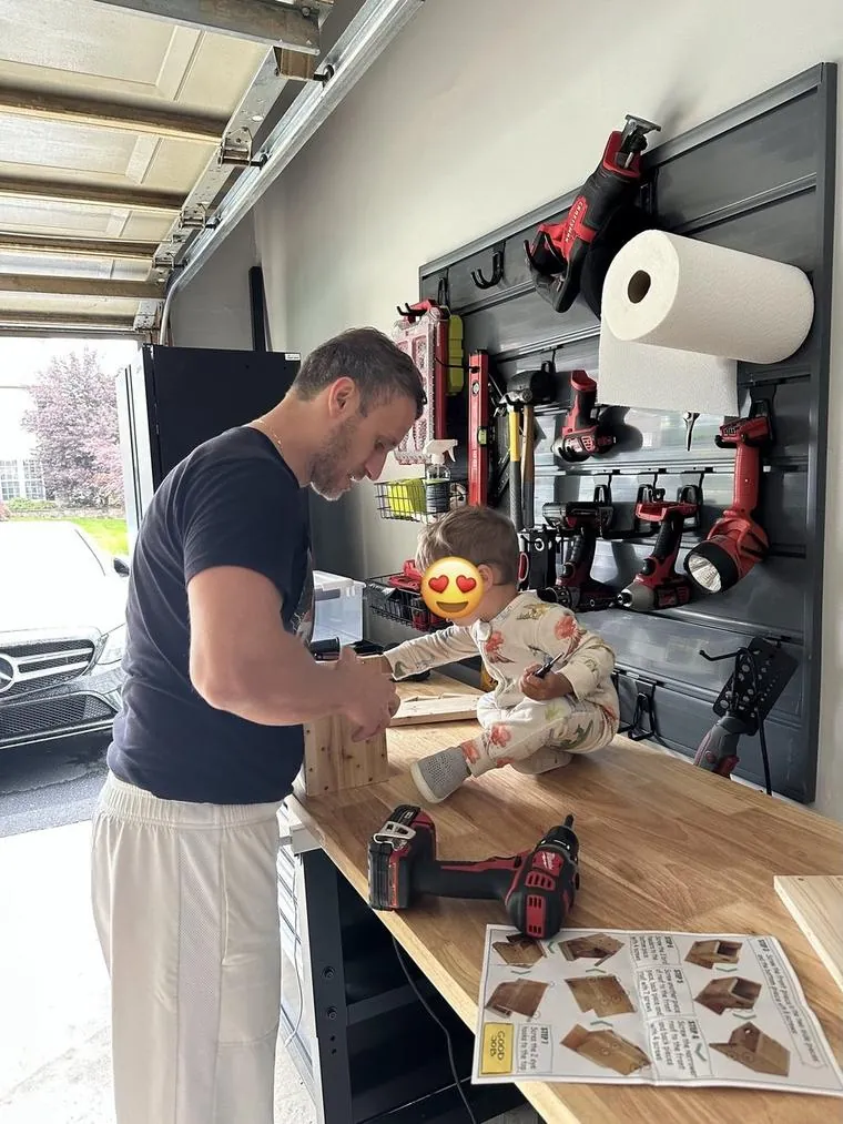 Me building a birdhouse at the garage workbench with my daughter