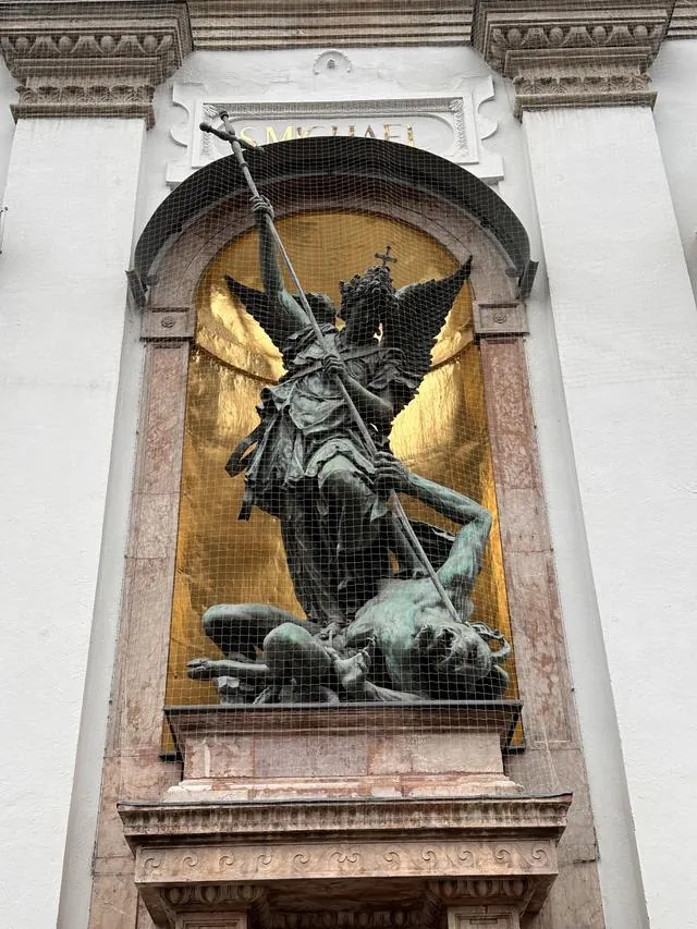 A bronze statue of Saint Michael on a church wall