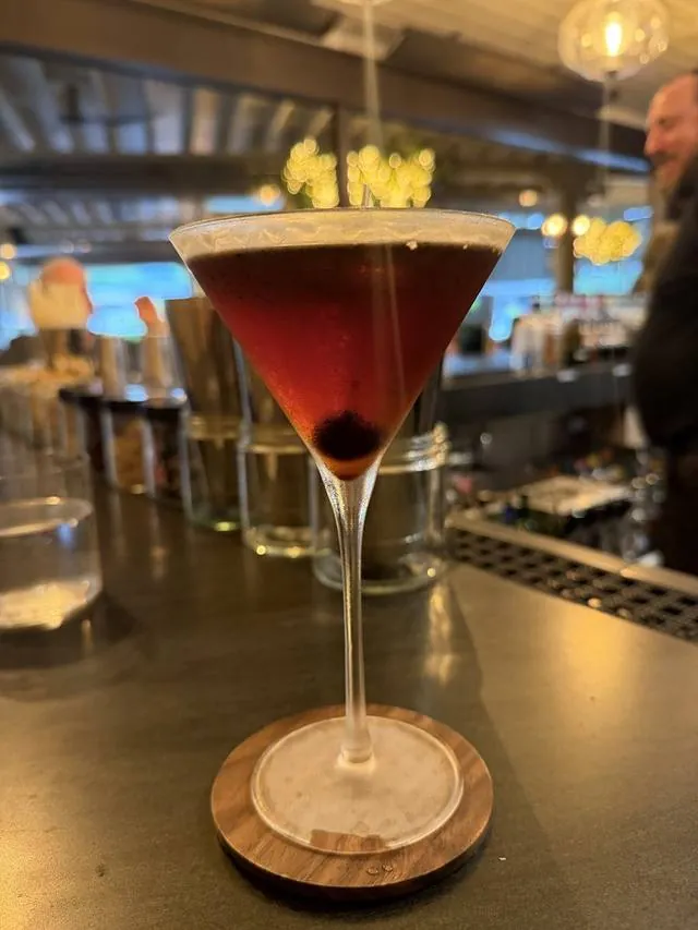 A Manhattan cocktail garnished on a bar top
